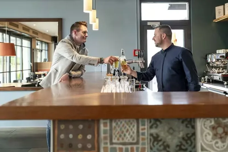 An der Bar wird ein Bier gezapft, unter der Theke die Zementfliesen