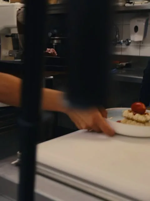In der Küche wird ein Dessert auf den Teller gesetzt