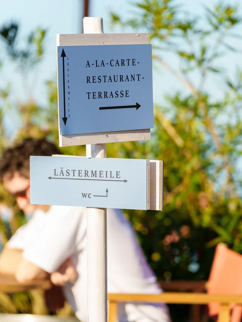 Wegweiser zur A-la-carte-Restaurant-Terrasse und zur Lästermeile